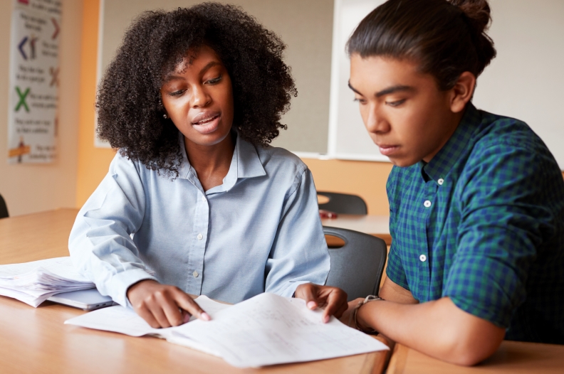 A teacher and a student looking over a book