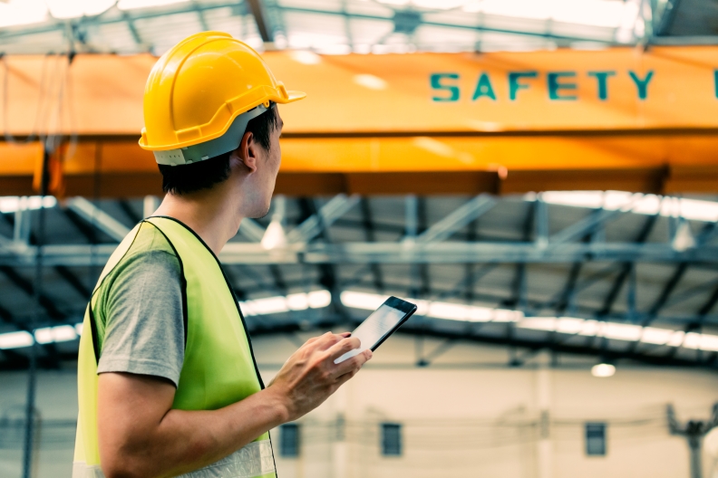 A person with a checklist looking at the word safety