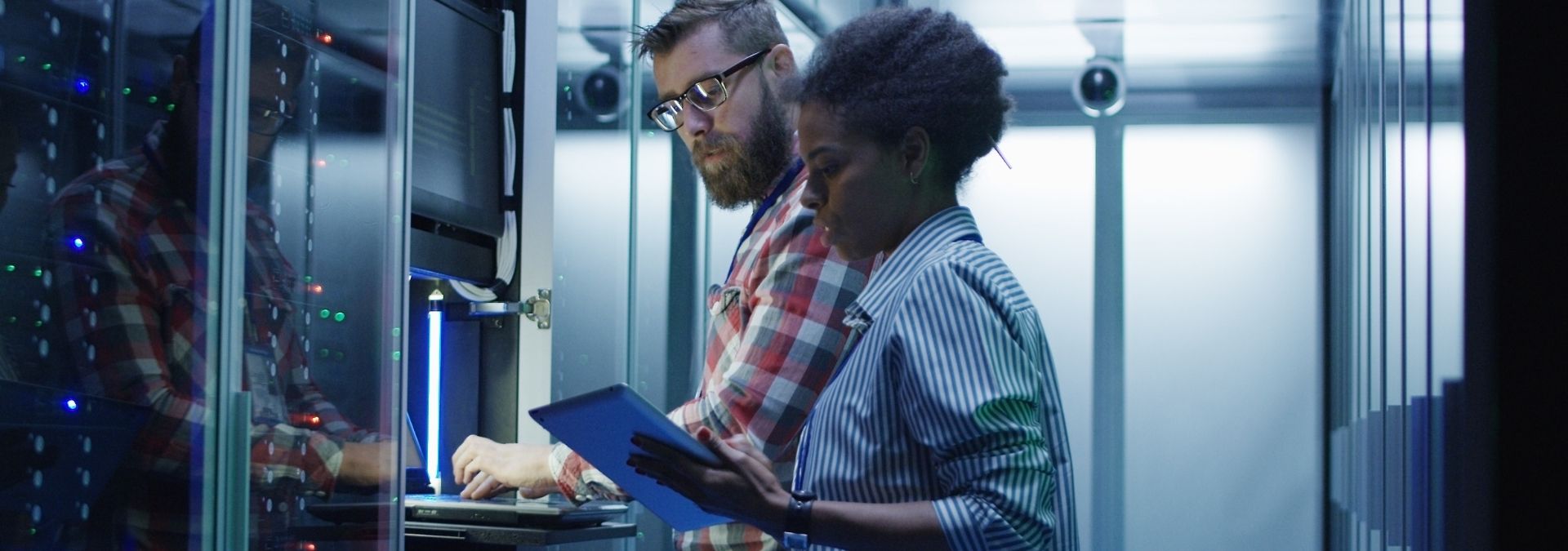 A man and a woman working at a computer server.